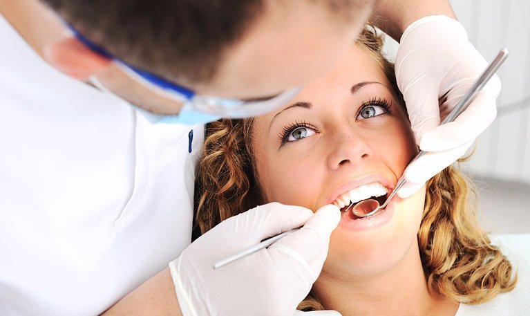 A modern and bright dental clinic interior for dental treatment in Turkey with a patient chair and advanced equipment.